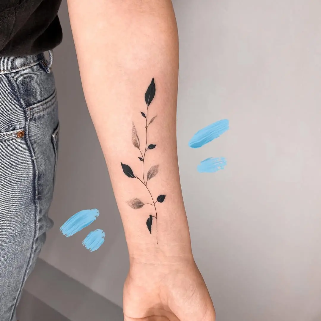 Elegant minimalist branch tattoo on forearm