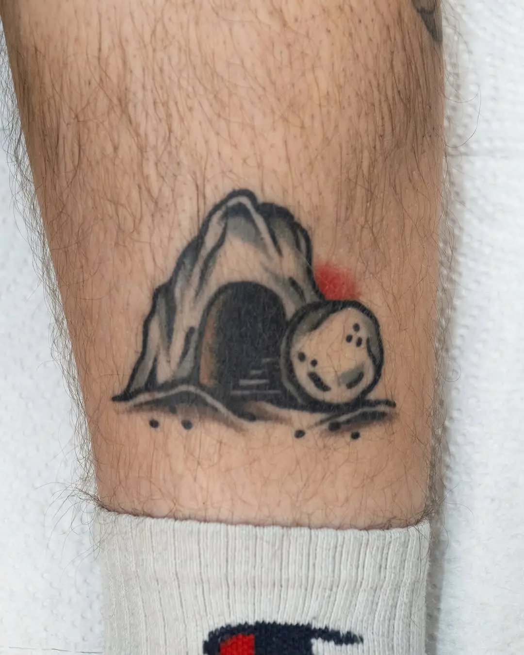 Symbolic resurrection cave tattoo with stone