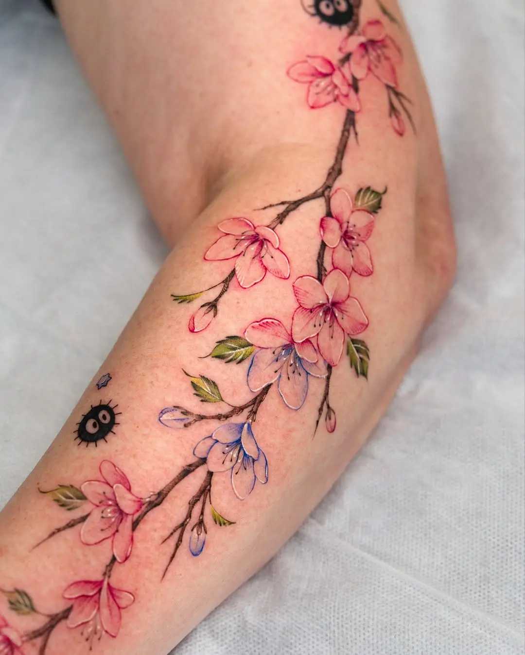 Elegant cherry blossom branch tattoo on arm