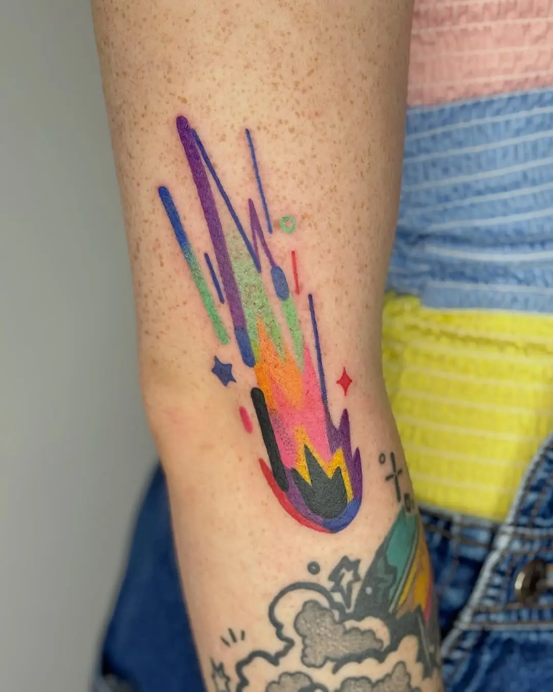 Vibrant meteor tattoo with colorful streaks