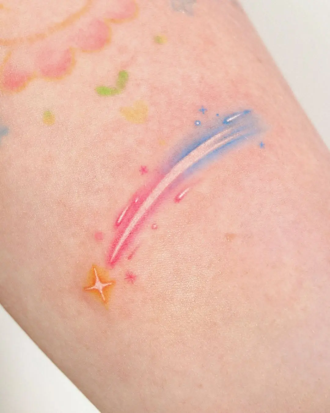 Vibrant meteor tattoo with starry accents