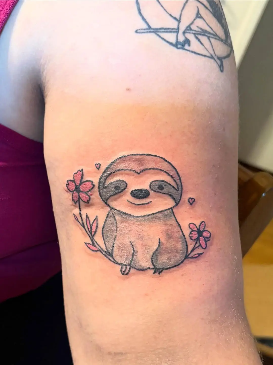 Charming sloth tattoo with floral accents