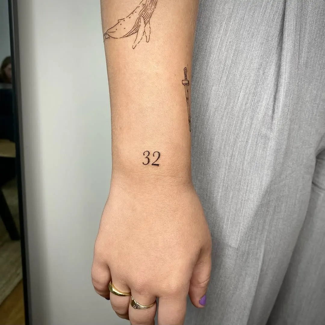 Elegant date tattoo on the forearm