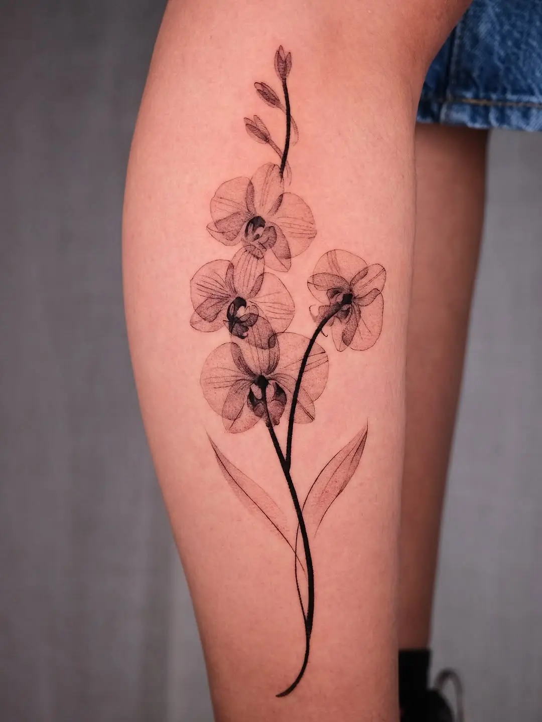 Delicate black orchid tattoo design on arm