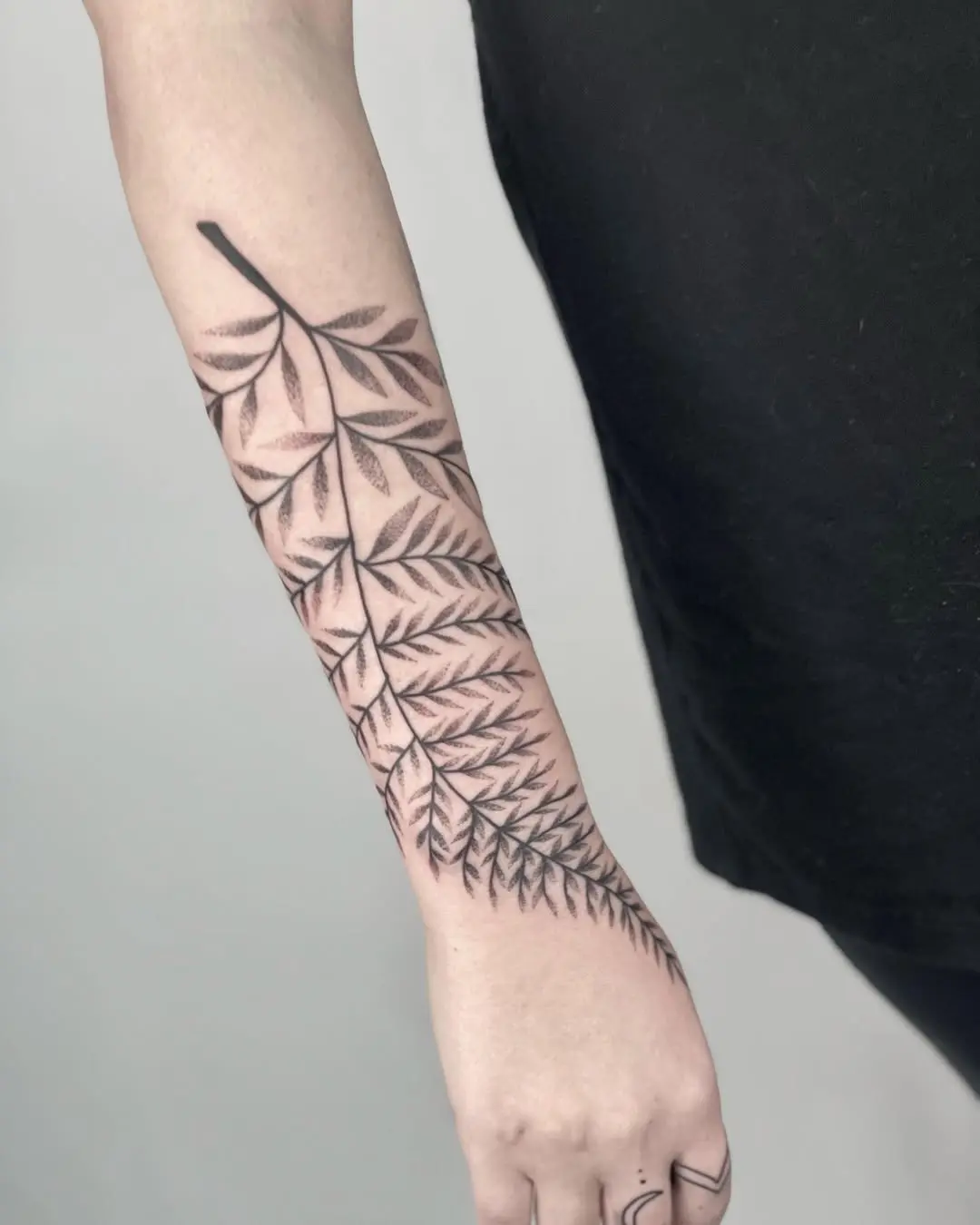 Elegant fern leaf tattoo on forearm