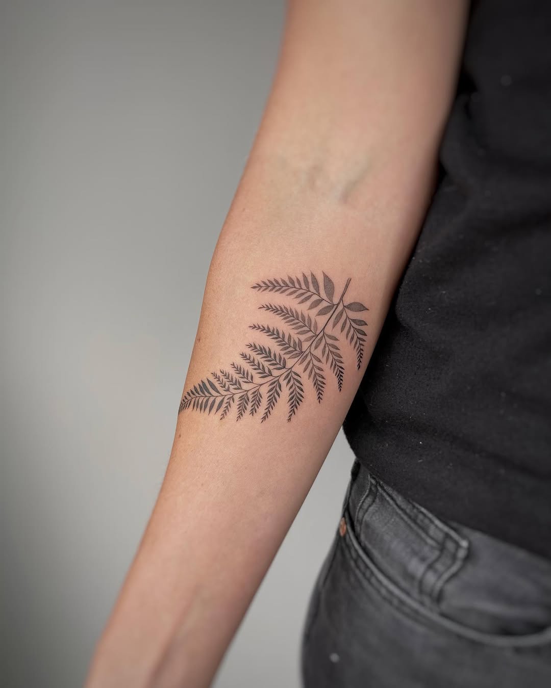 Elegant fern leaf tattoo design on forearm