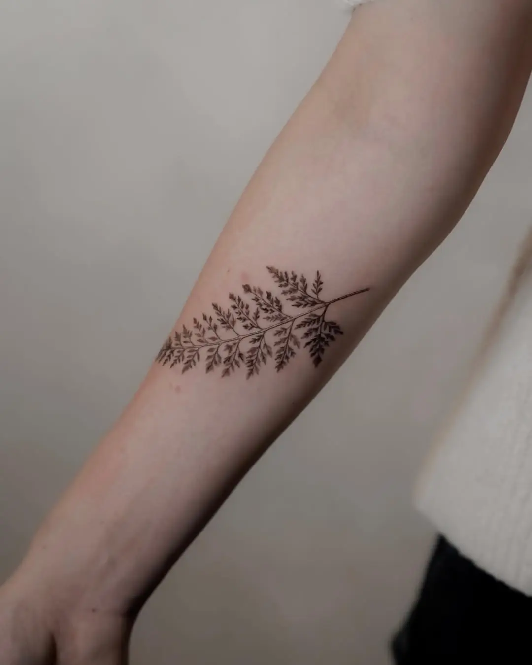 Elegant fern leaf tattoo on the forearm