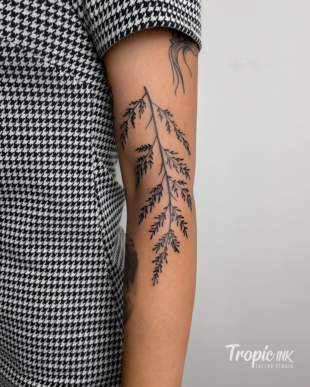 Elegant fern leaf tattoo in black ink