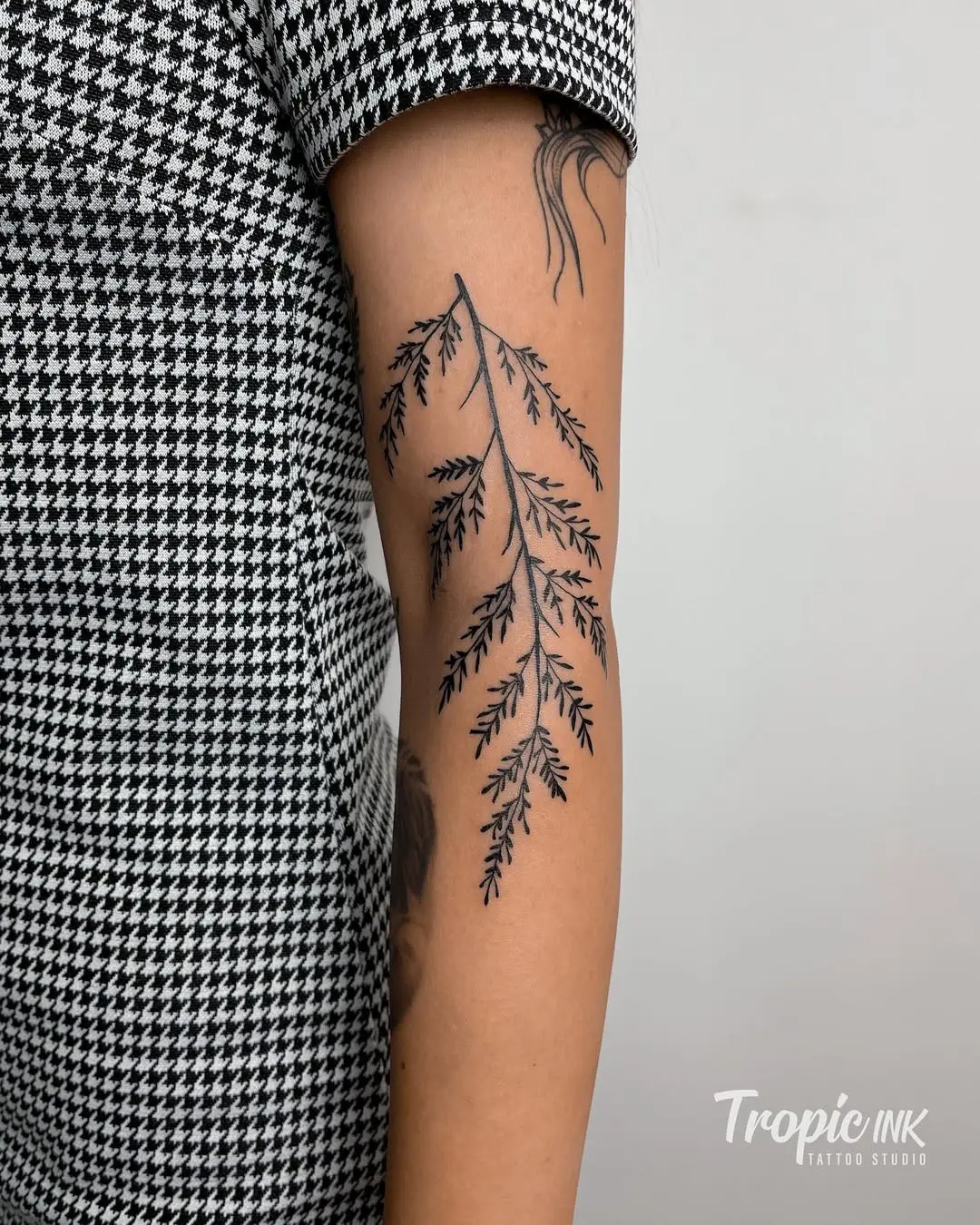 Elegant fern leaf tattoo in black ink