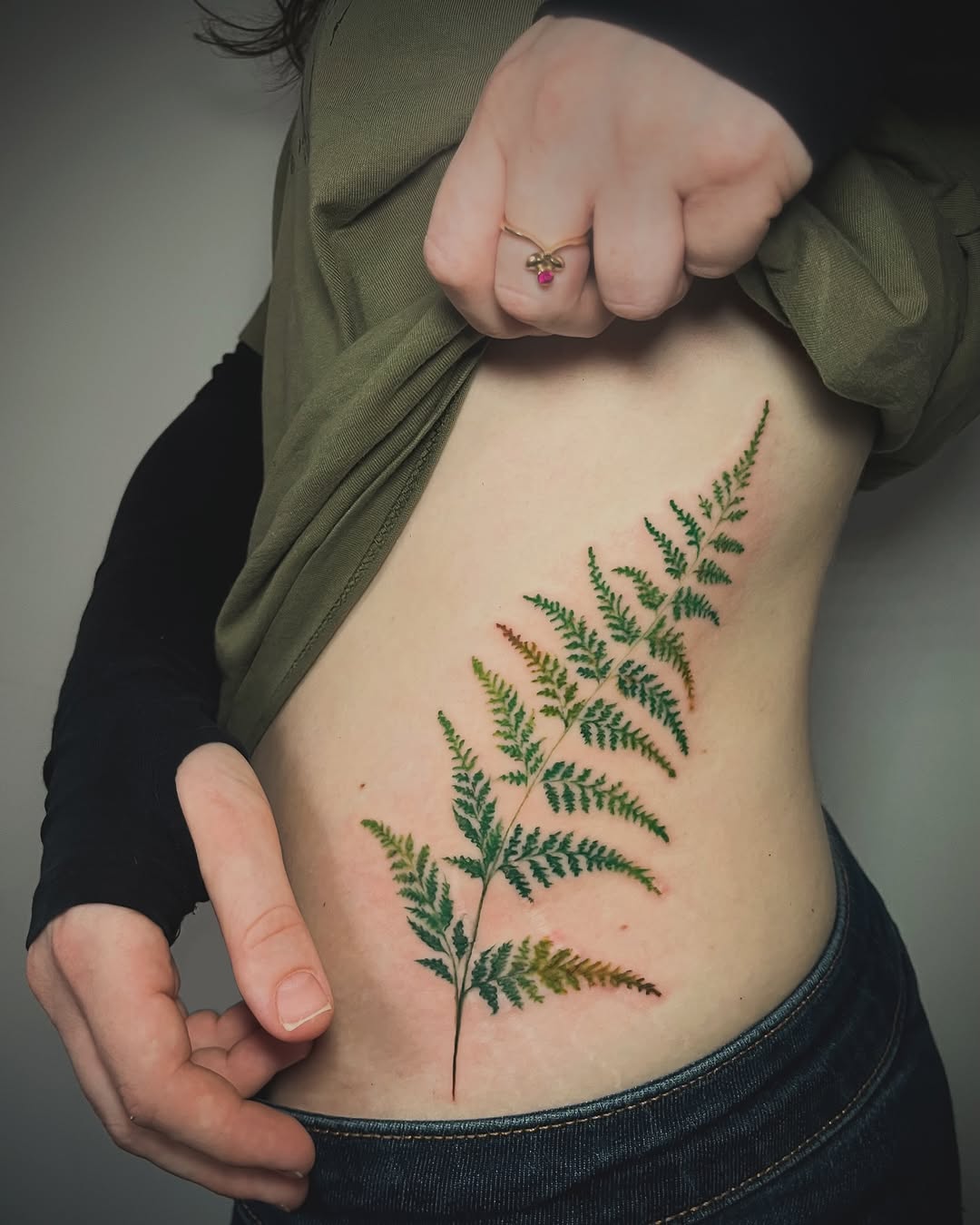 Vibrant fern tattoo on the side body