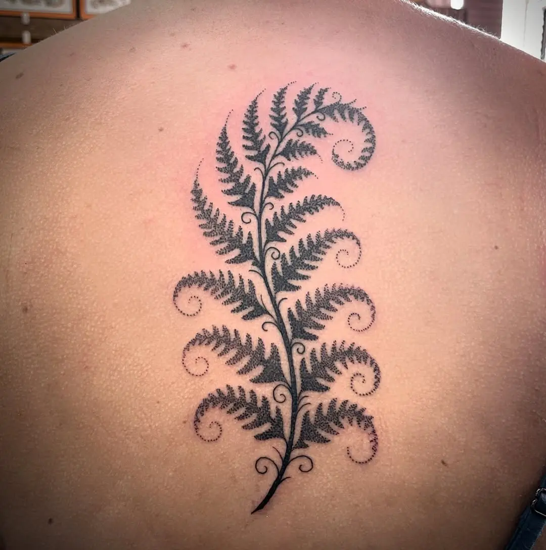 Elegant fern tattoo cascading down the back