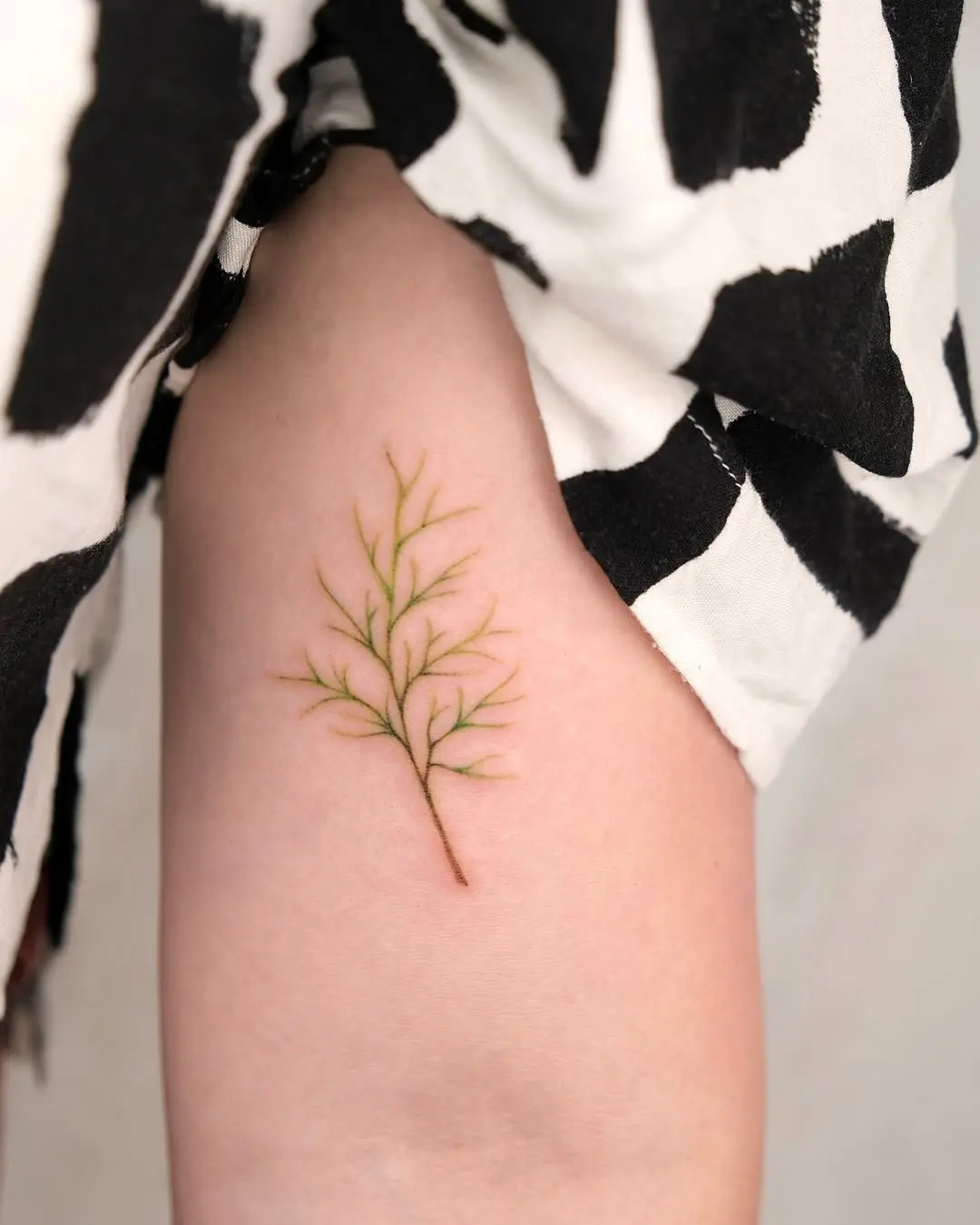 A delicate fern tattoo highlighting natural beauty.