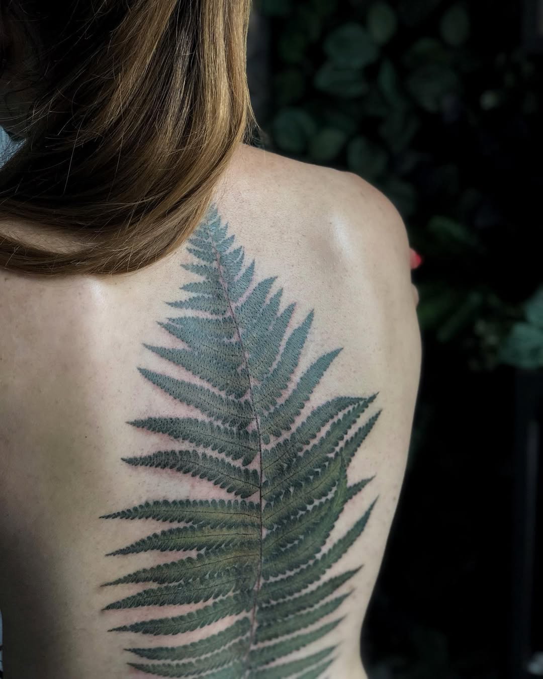 Elegant fern leaf tattoo on the back