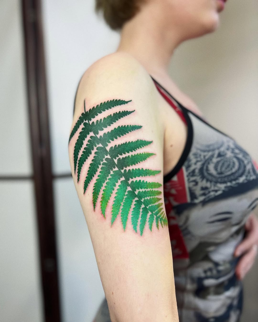 Vibrant Green Fern Leaf Tattoo on Arm