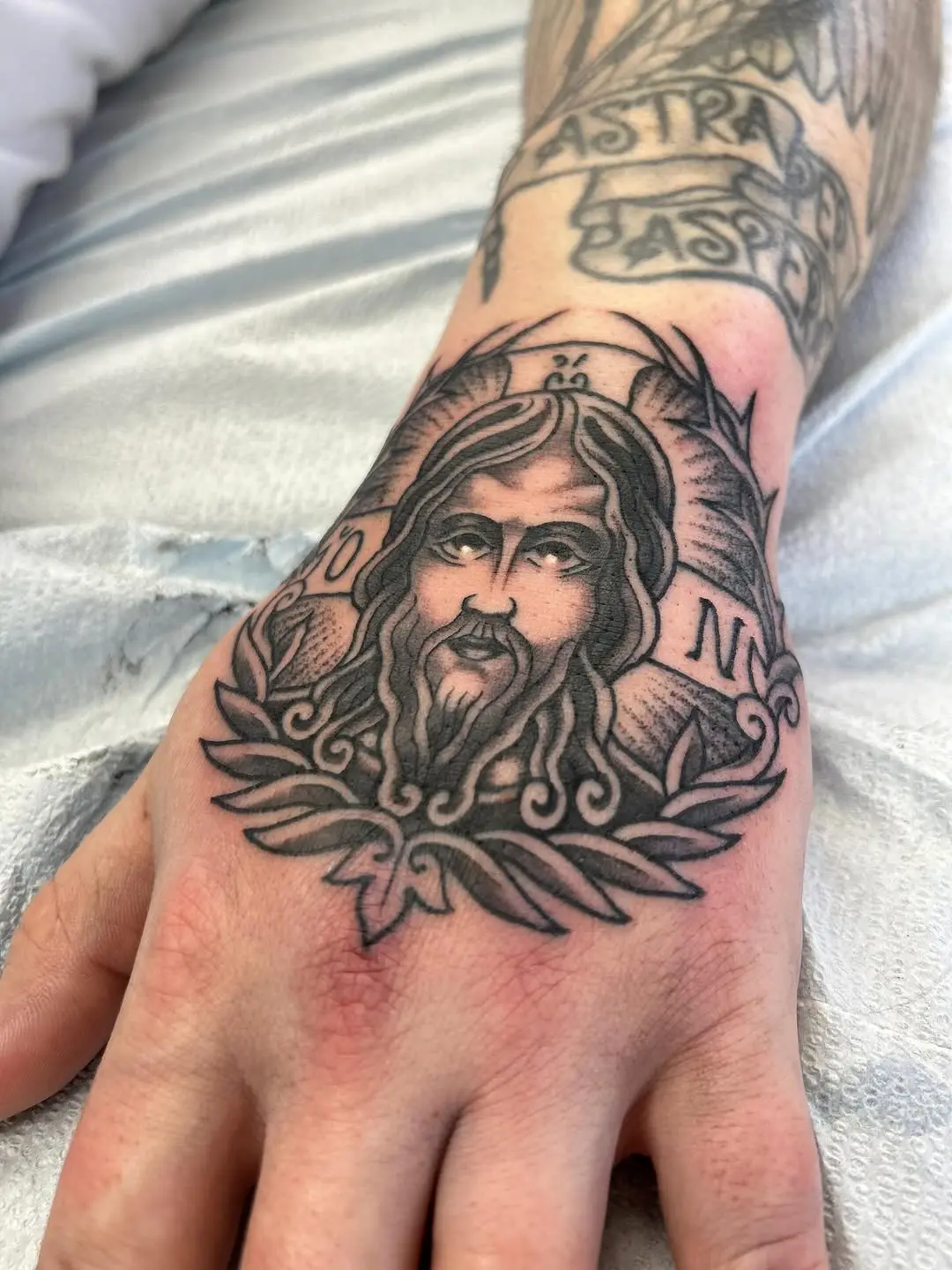 Detailed black ink Jesus hand tattoo art