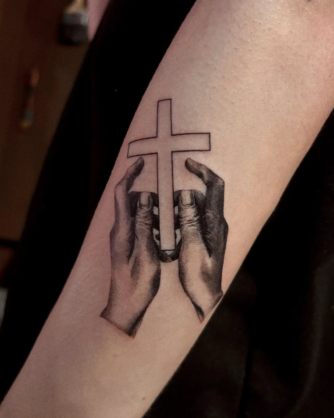 Symbolic hands embracing a cross design