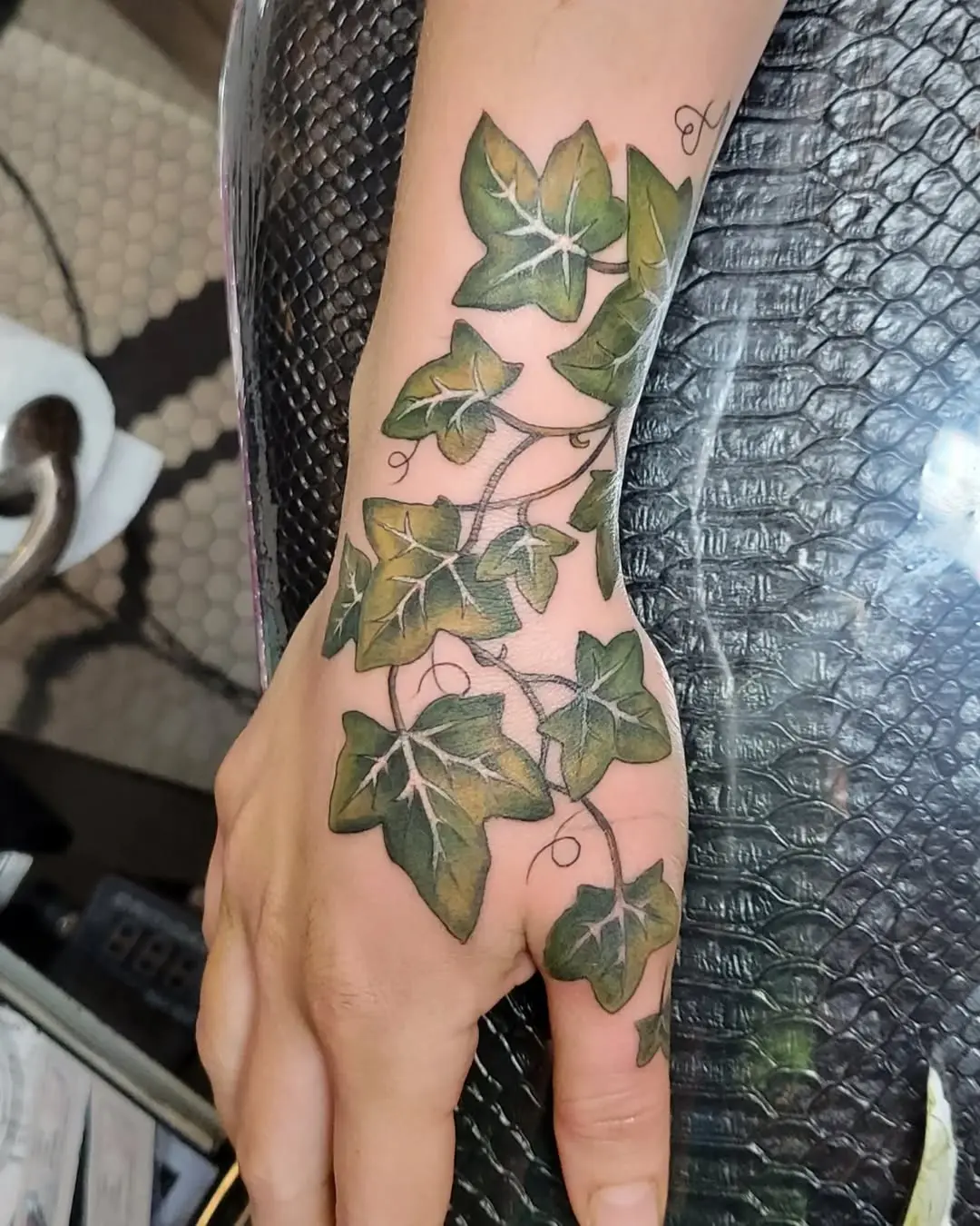 Elegant ivy tattoo wrapping around hand