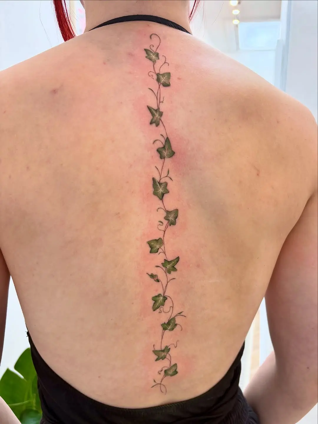 Elegant vertical ivy tattoo on the back