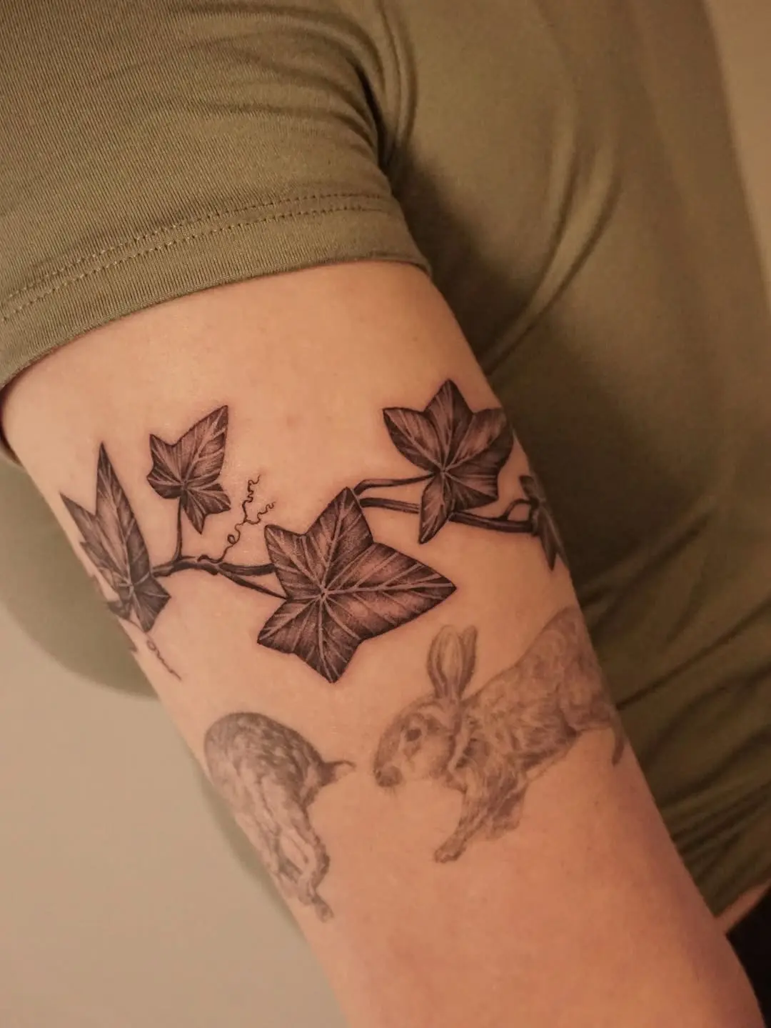 Elegant ivy tattoo intertwined with playful rabbits