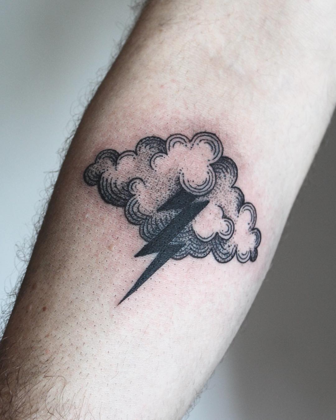 Stylish lightning bolt tattoo amidst cloudy design