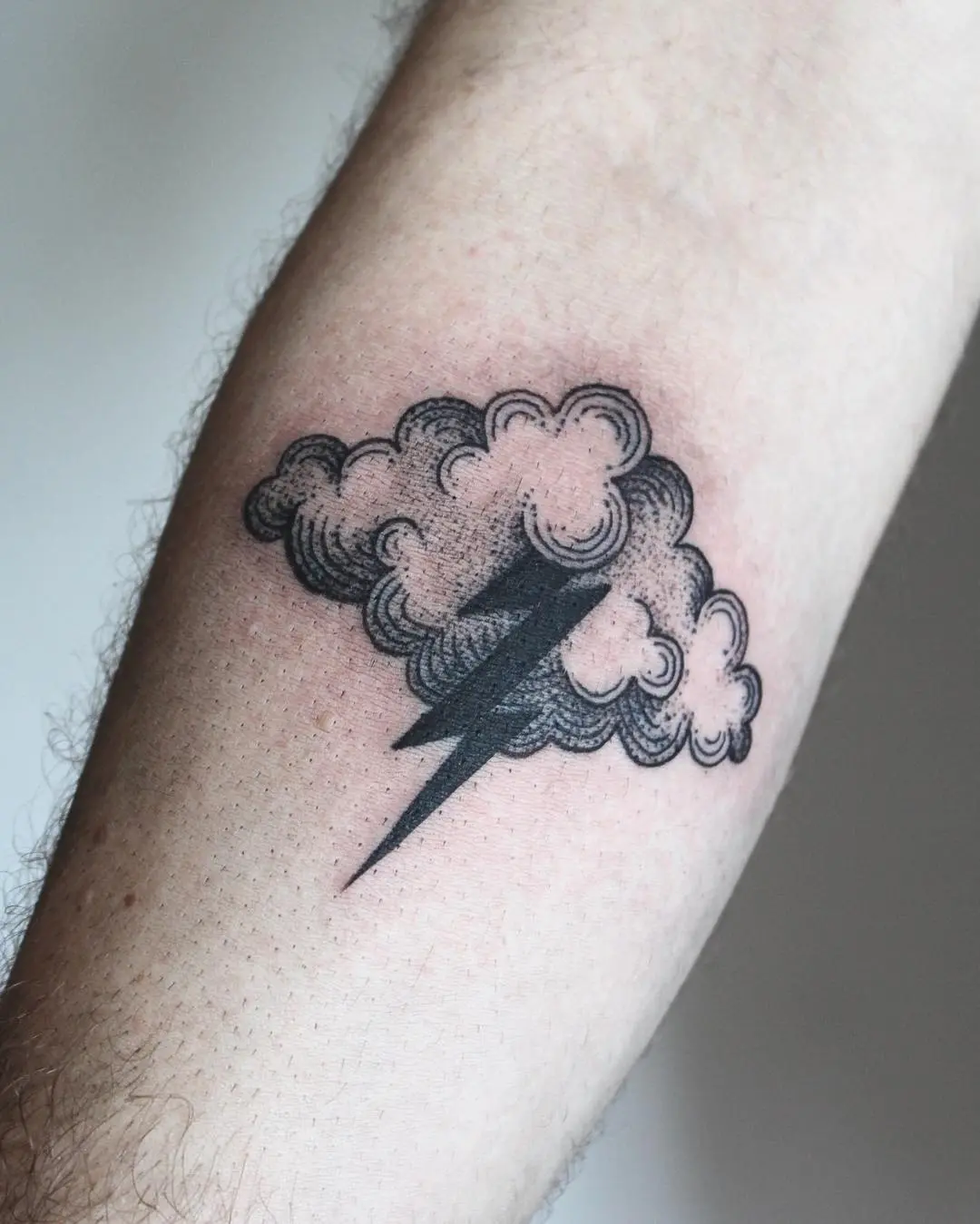 Stylish lightning bolt tattoo amidst cloudy design