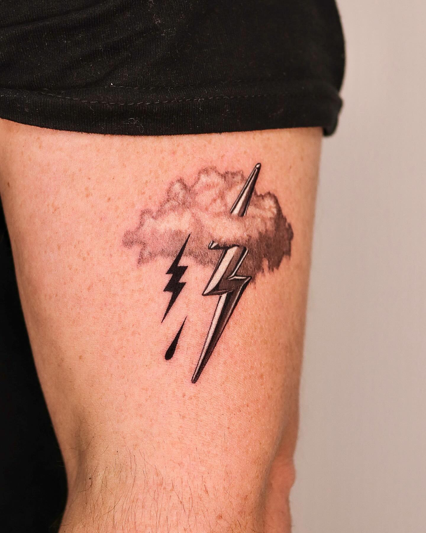 Striking lightning bolt tattoo with cloud design
