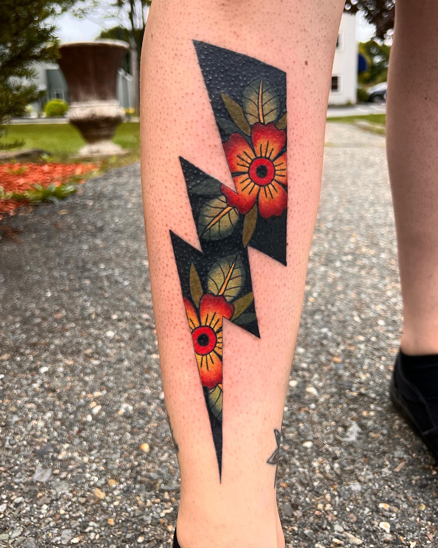 Vibrant lightning bolt tattoo with floral accents
