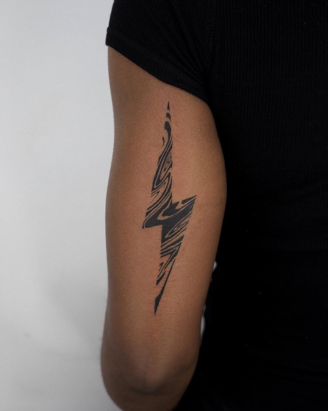 Sleek lightning bolt tattoo in abstract style