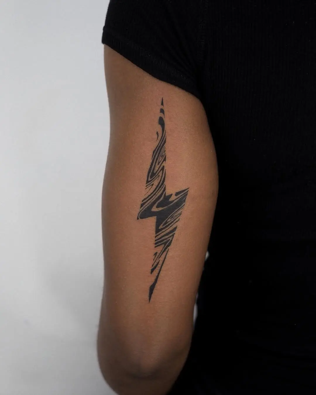 Sleek lightning bolt tattoo in abstract style