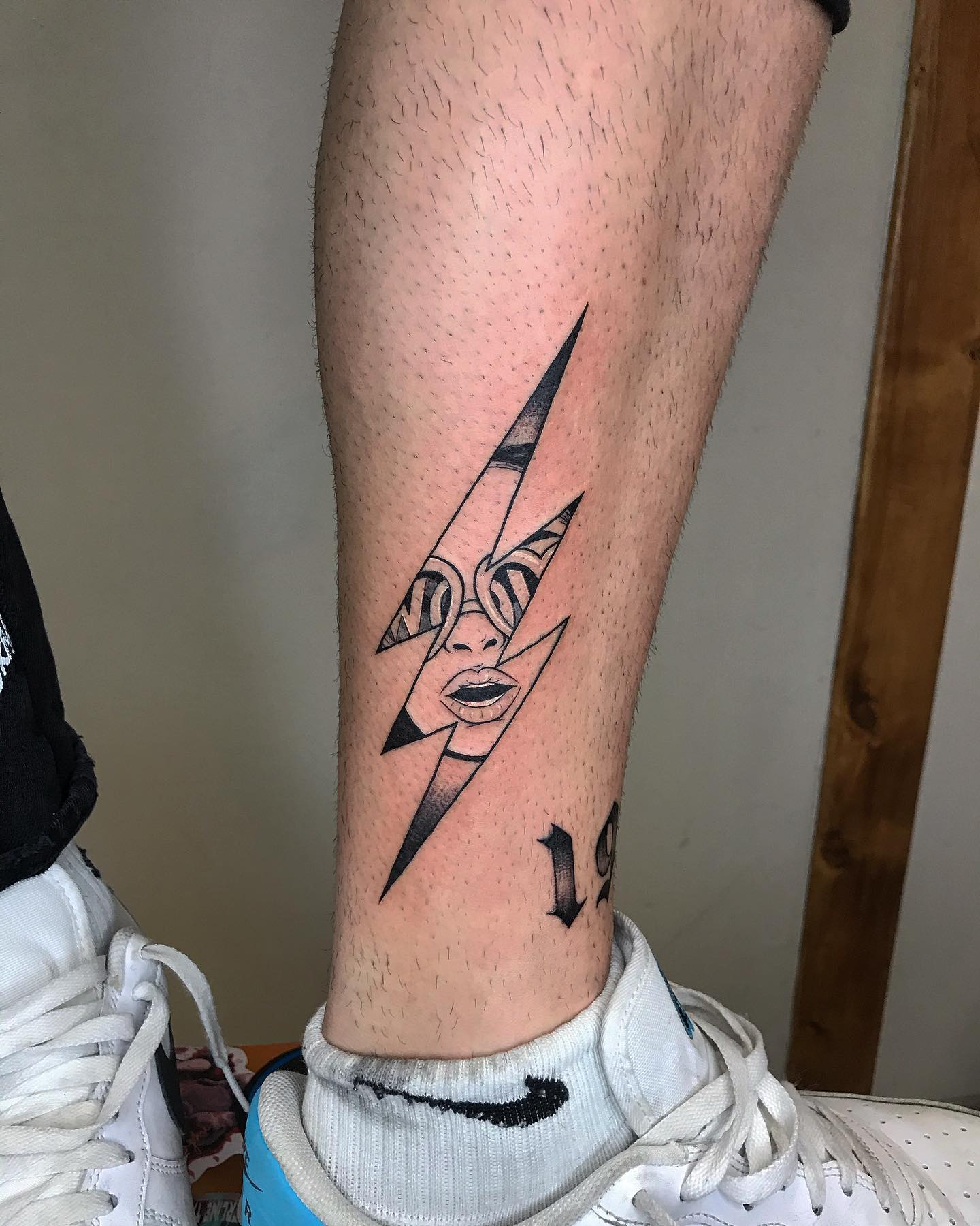 Striking lightning bolt tattoo featuring a face