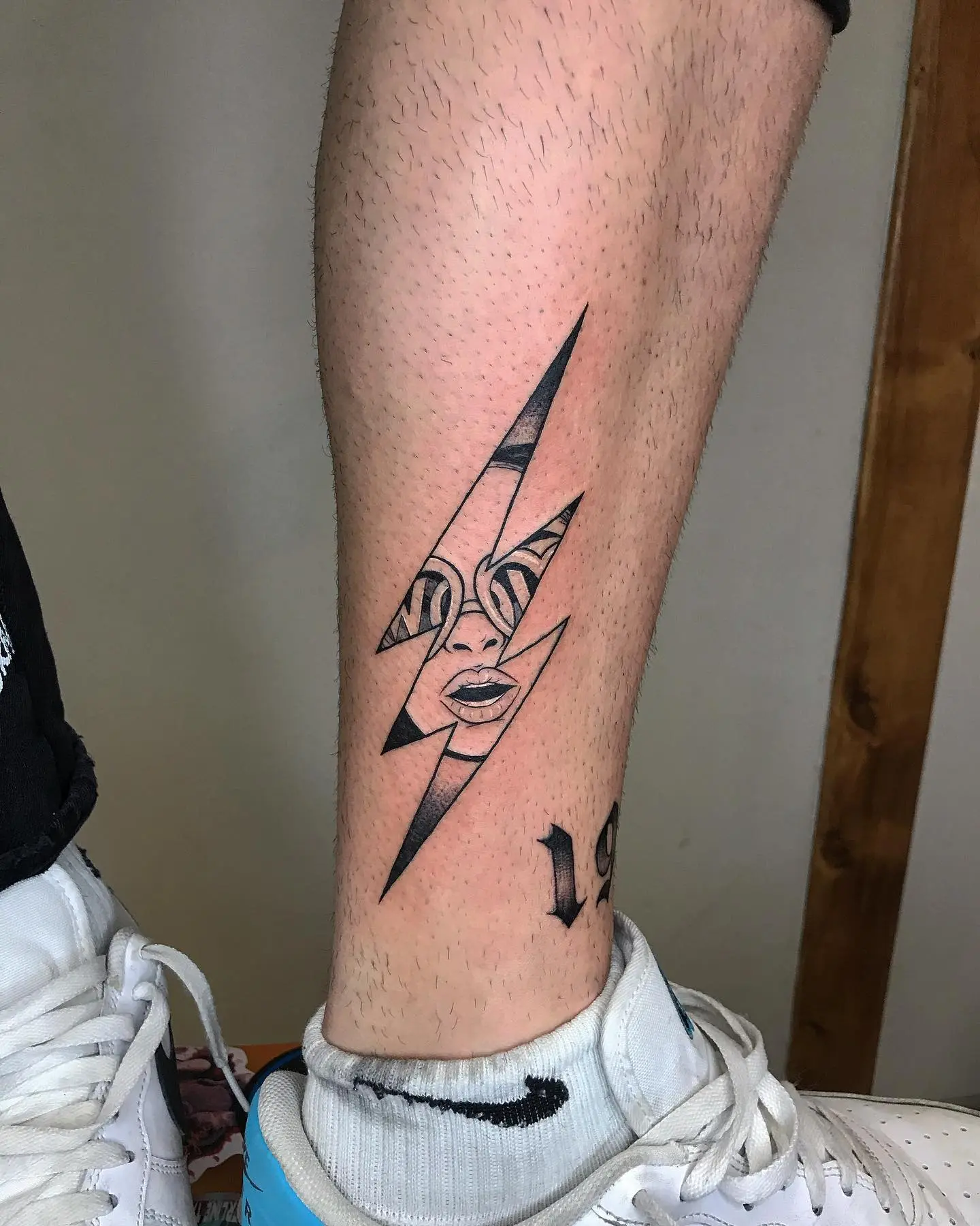 Striking lightning bolt tattoo featuring a face