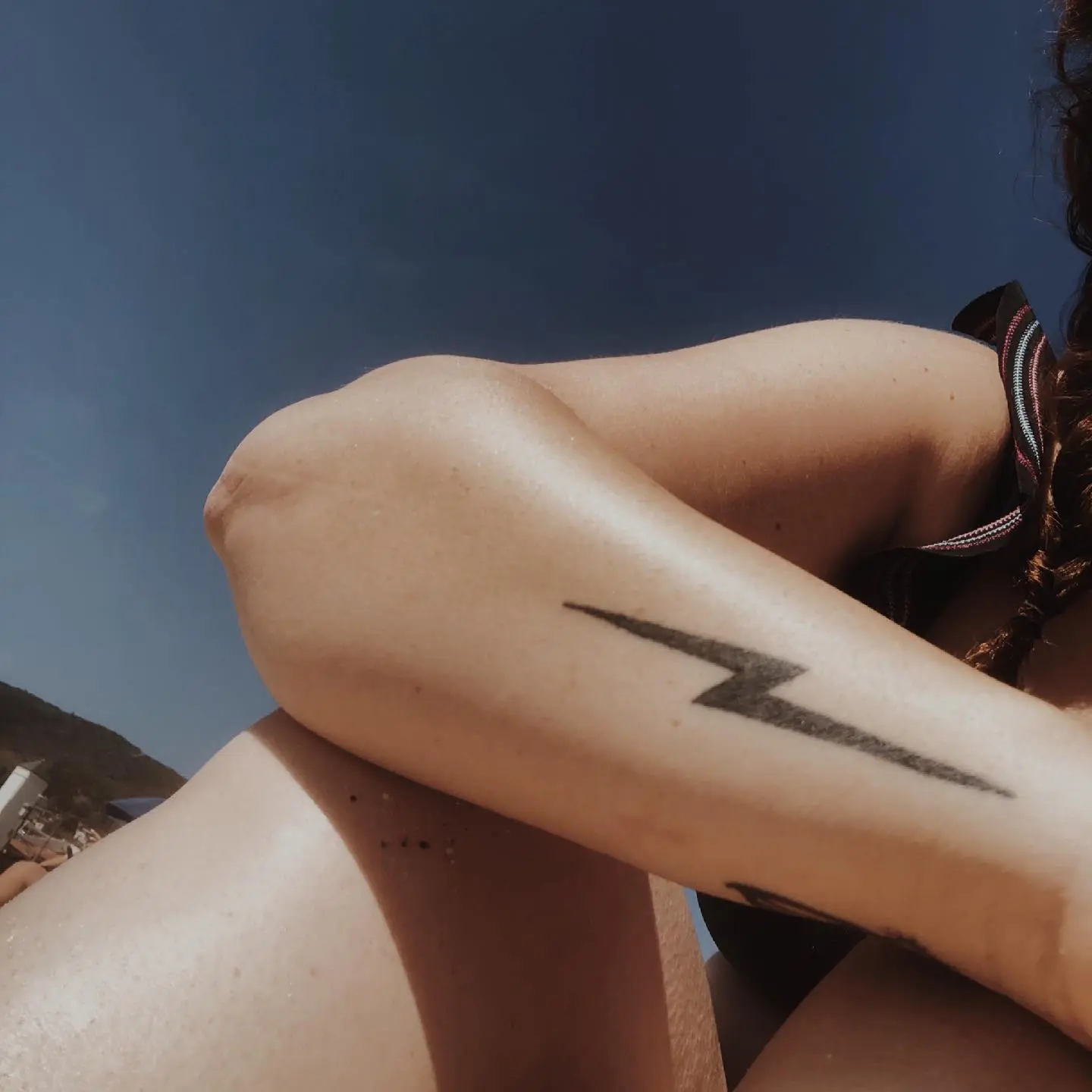 Sleek black lightning bolt tattoo on arm