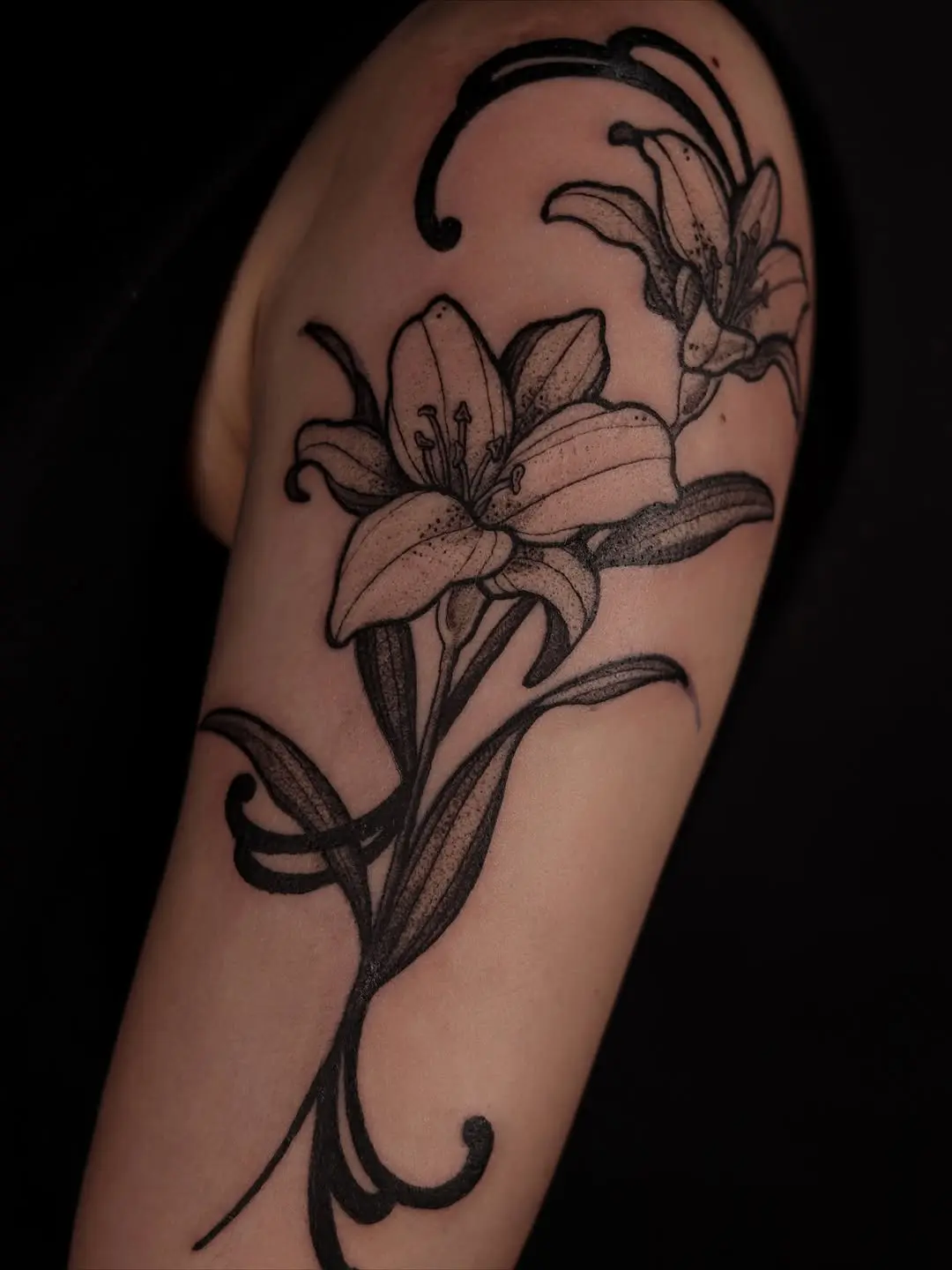 Elegant black ink lily tattoo design
