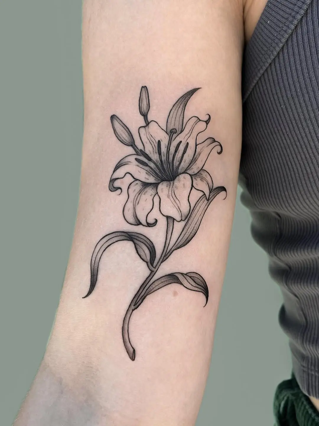 Elegant black ink lily tattoo design
