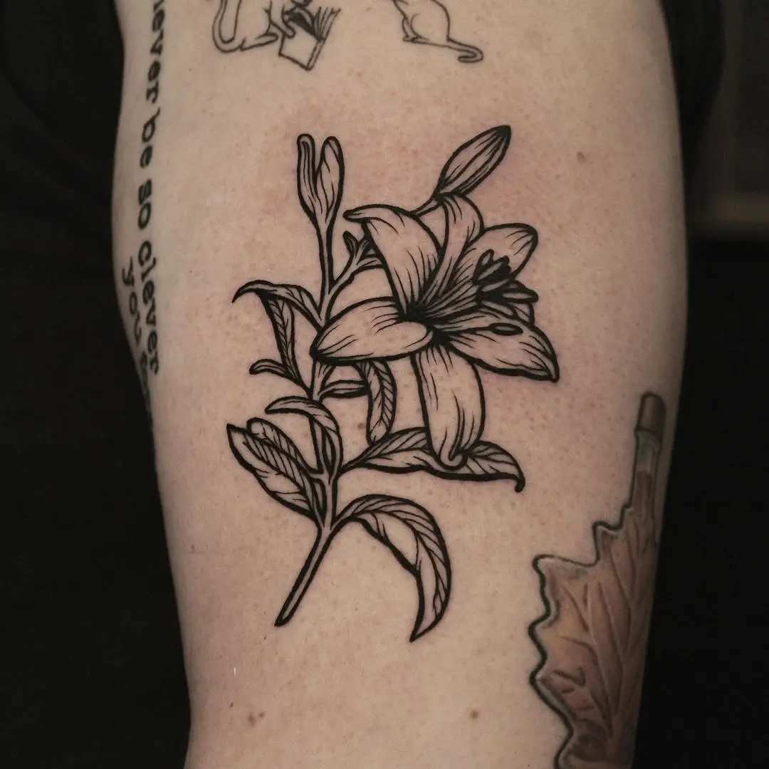 Elegant black ink lily tattoo on arm