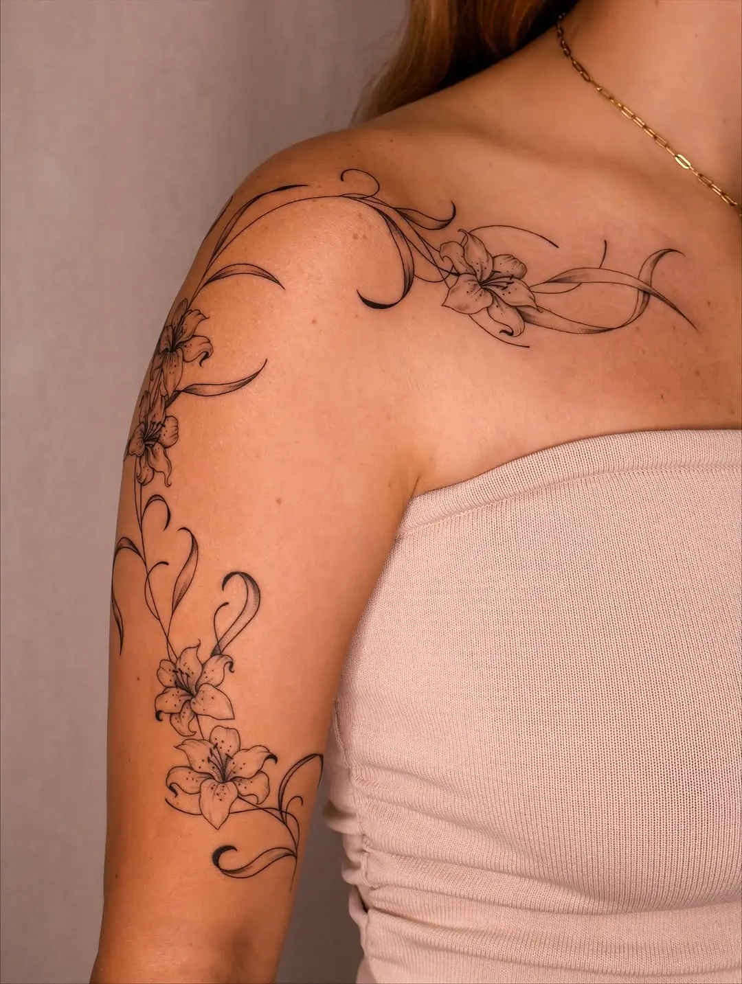 Elegant floral sleeve tattoo featuring lilies