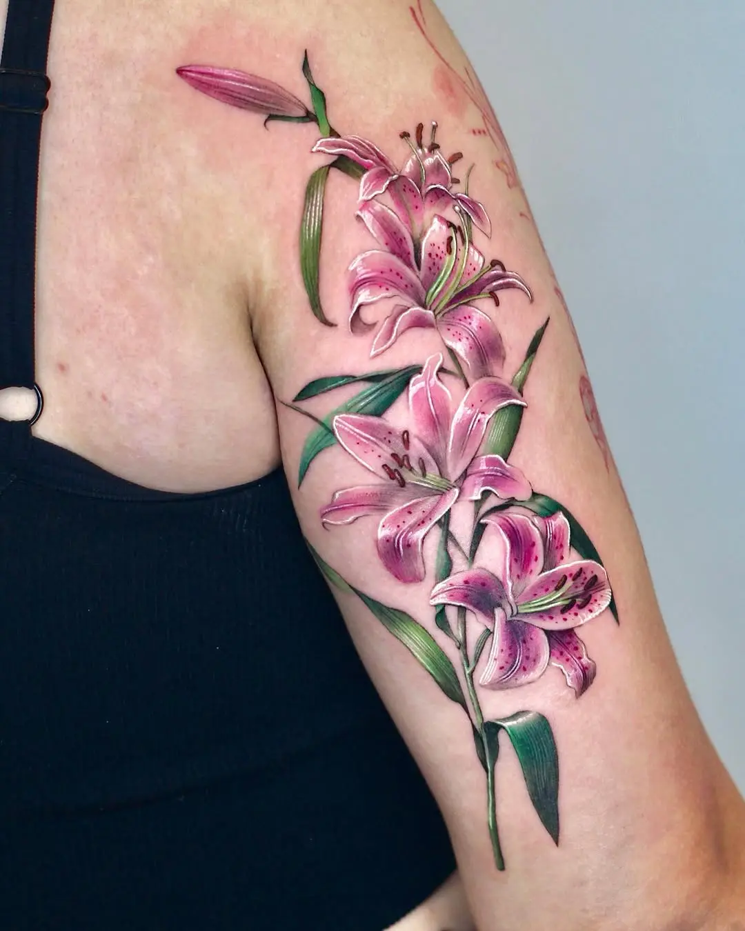 Elegant pink lily tattoo adorning the arm