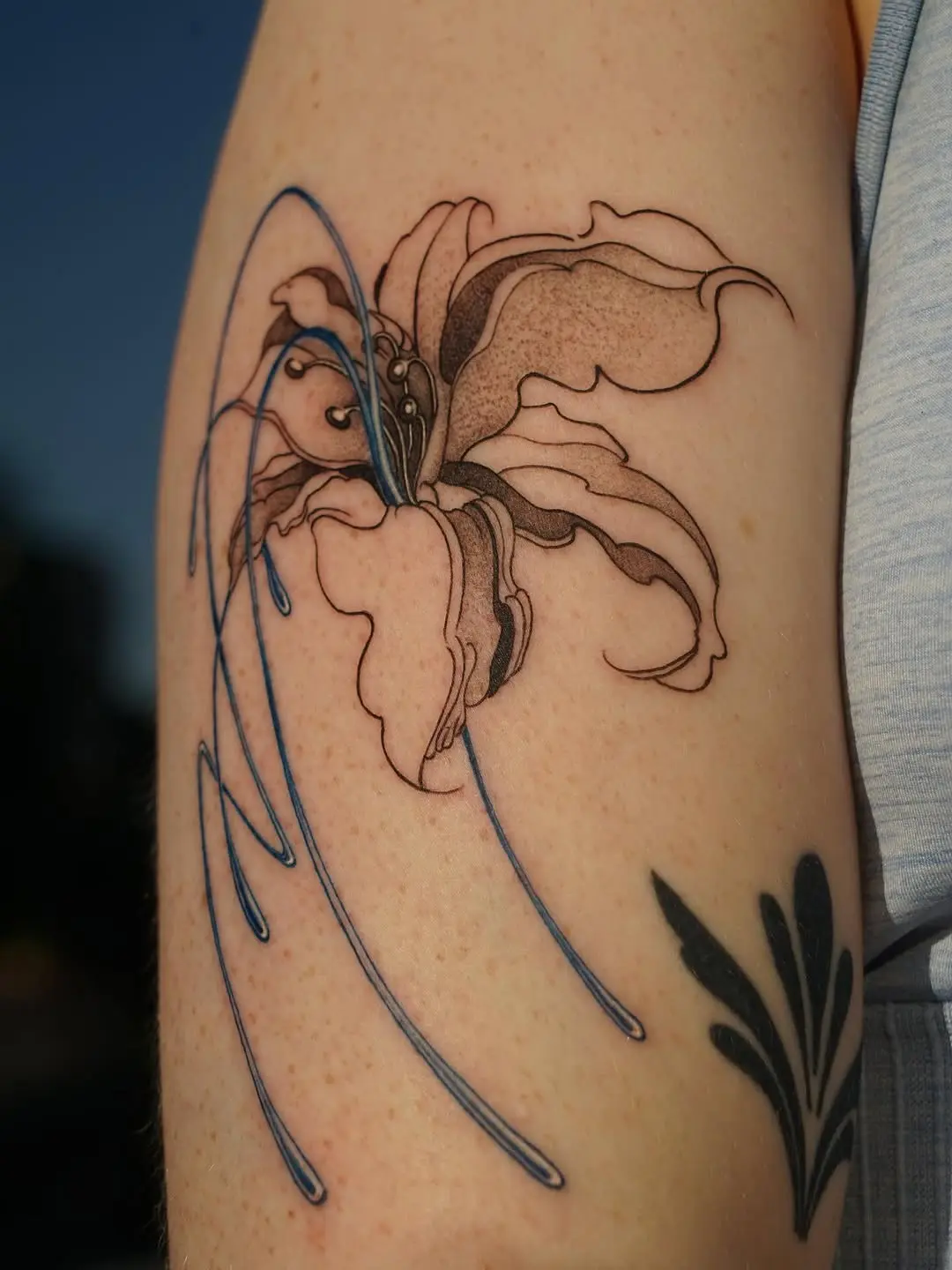 Elegant lily tattoo with flowing water design