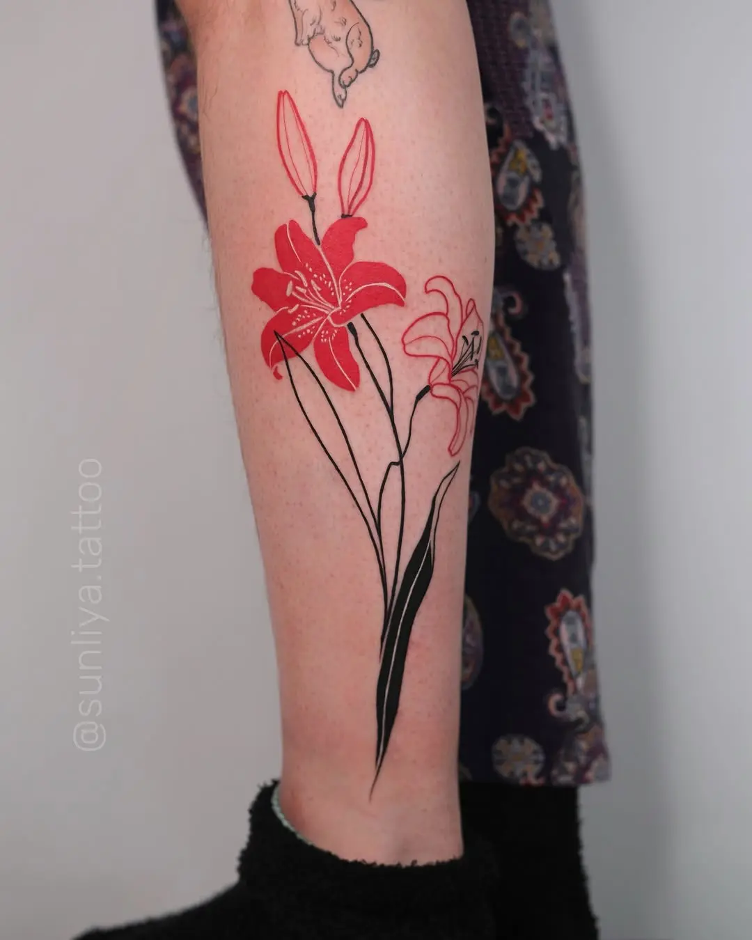 Stunning red and black lily tattoo design
