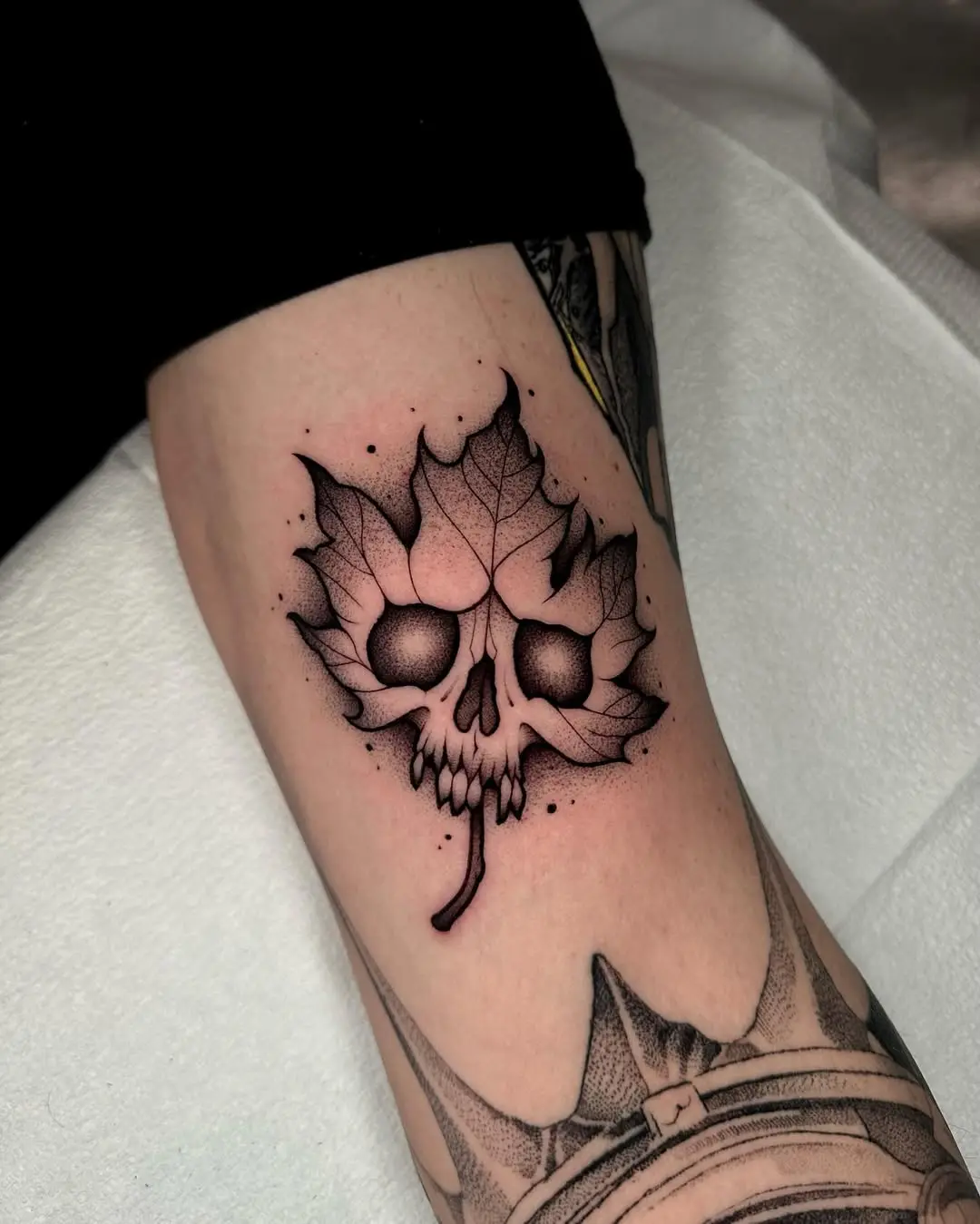 Intricate maple leaf skull tattoo design