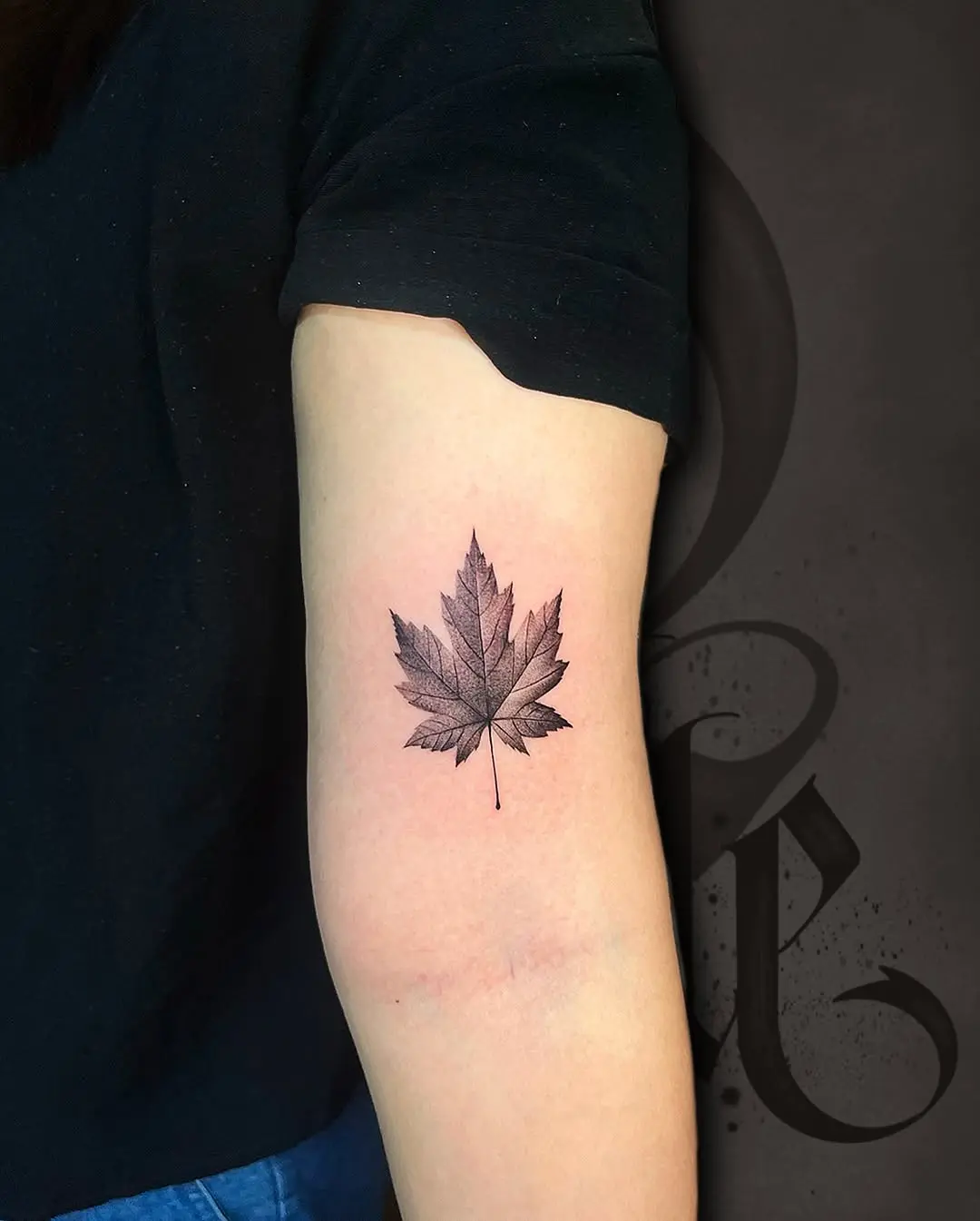 Elegant black ink maple leaf tattoo design