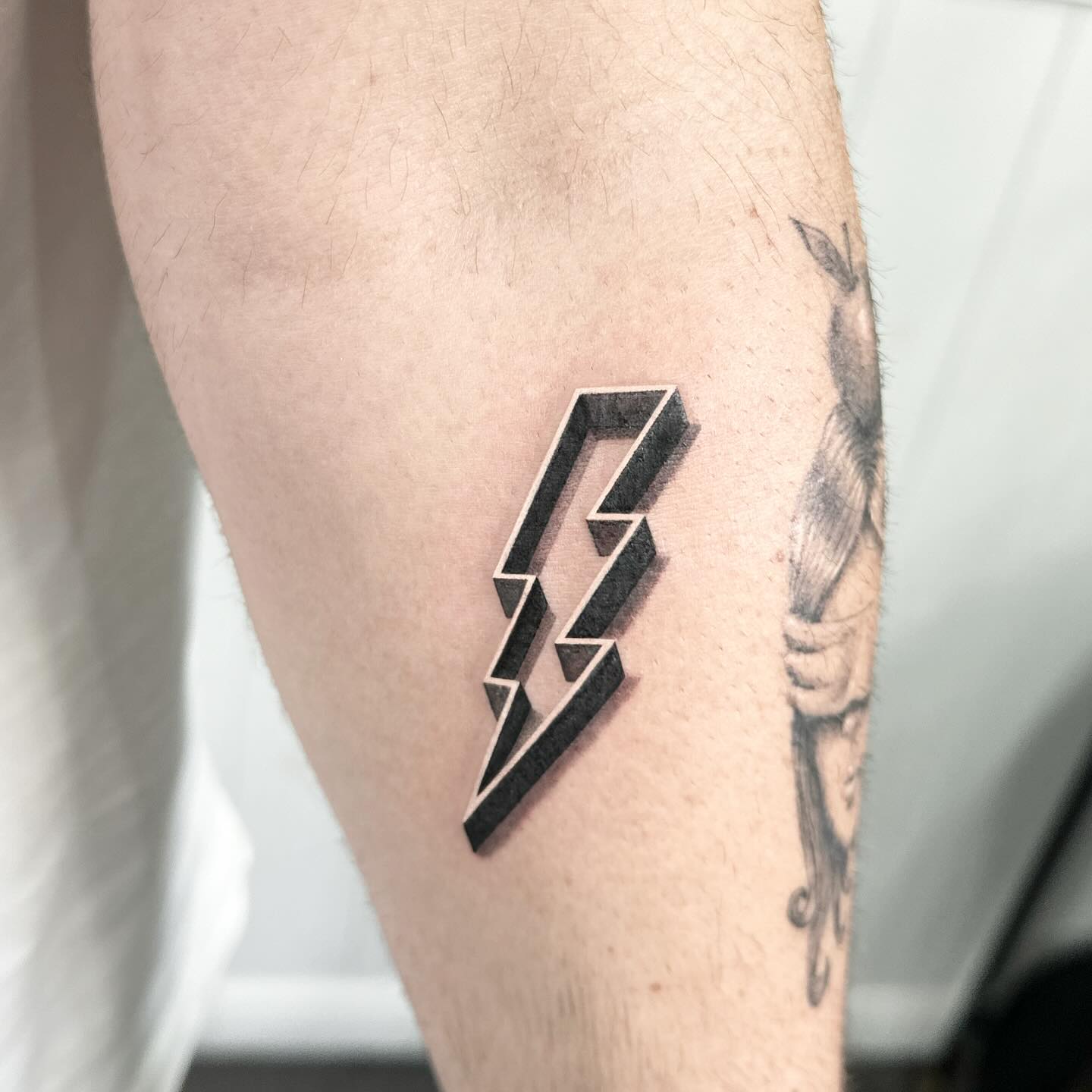 Sleek lightning bolt tattoo on the forearm