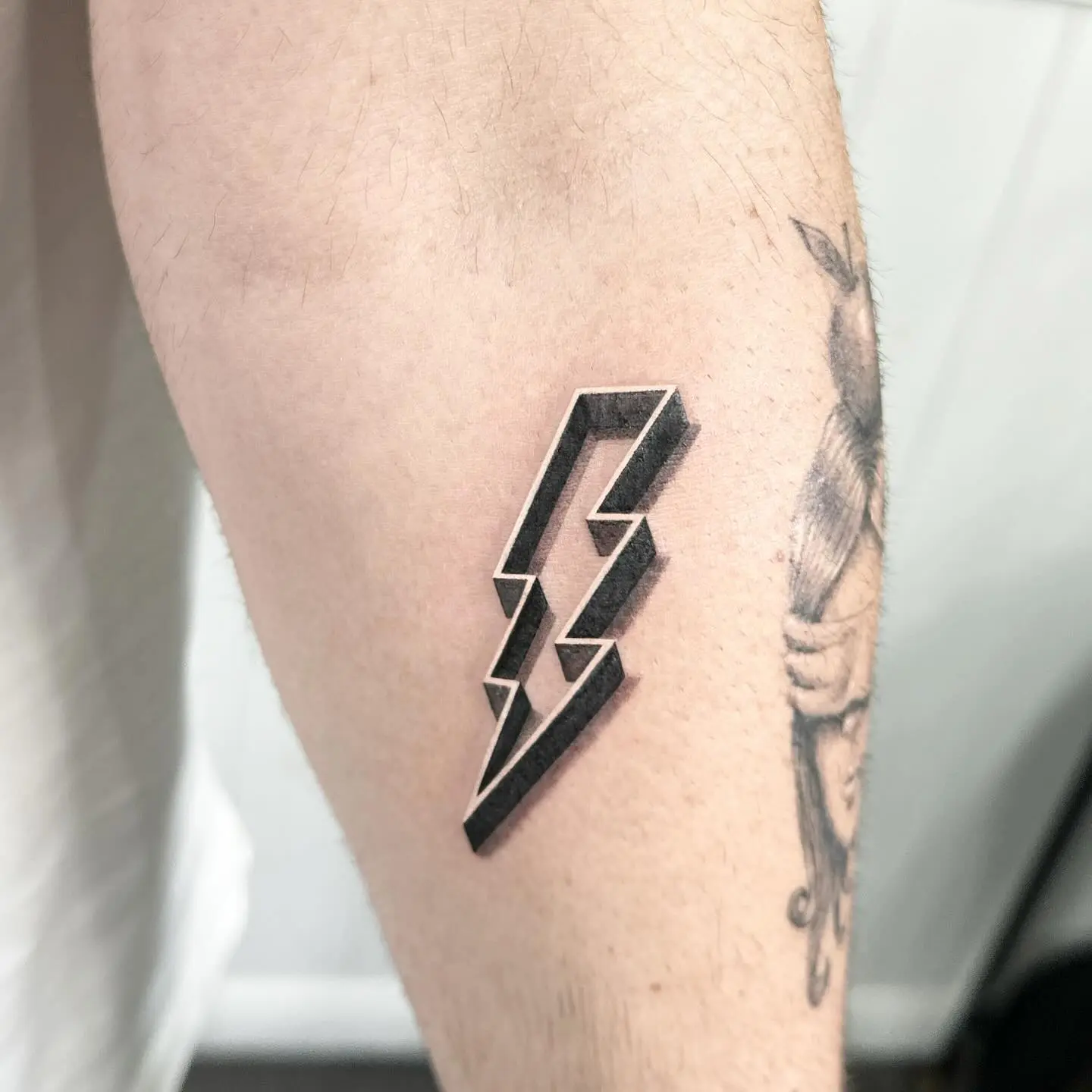 Sleek lightning bolt tattoo on the forearm