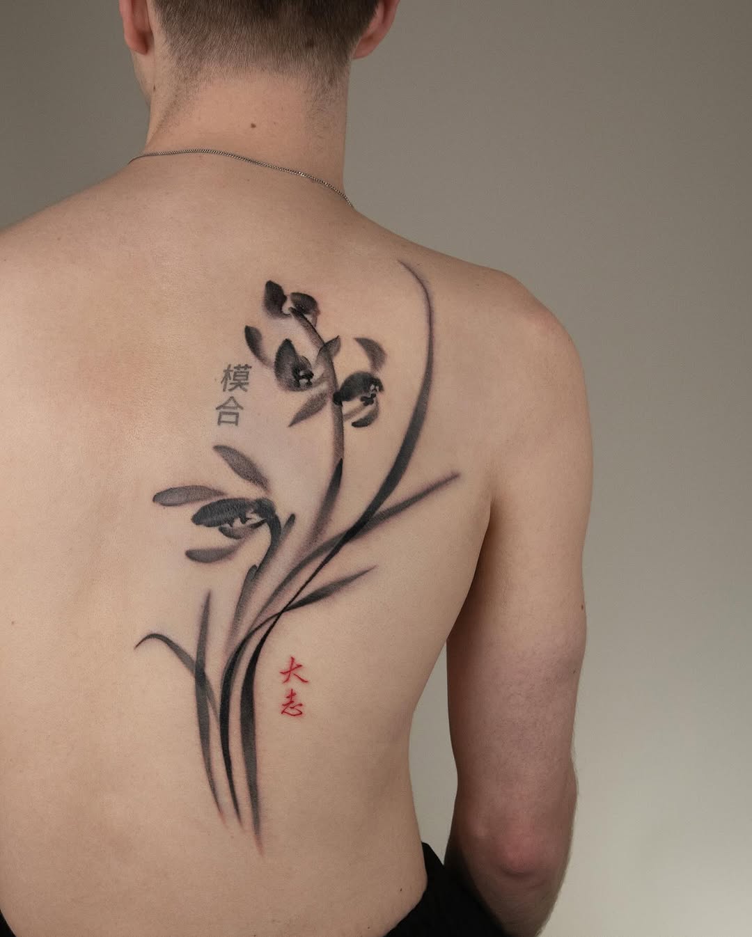 Elegant orchid tattoo with bold black ink.