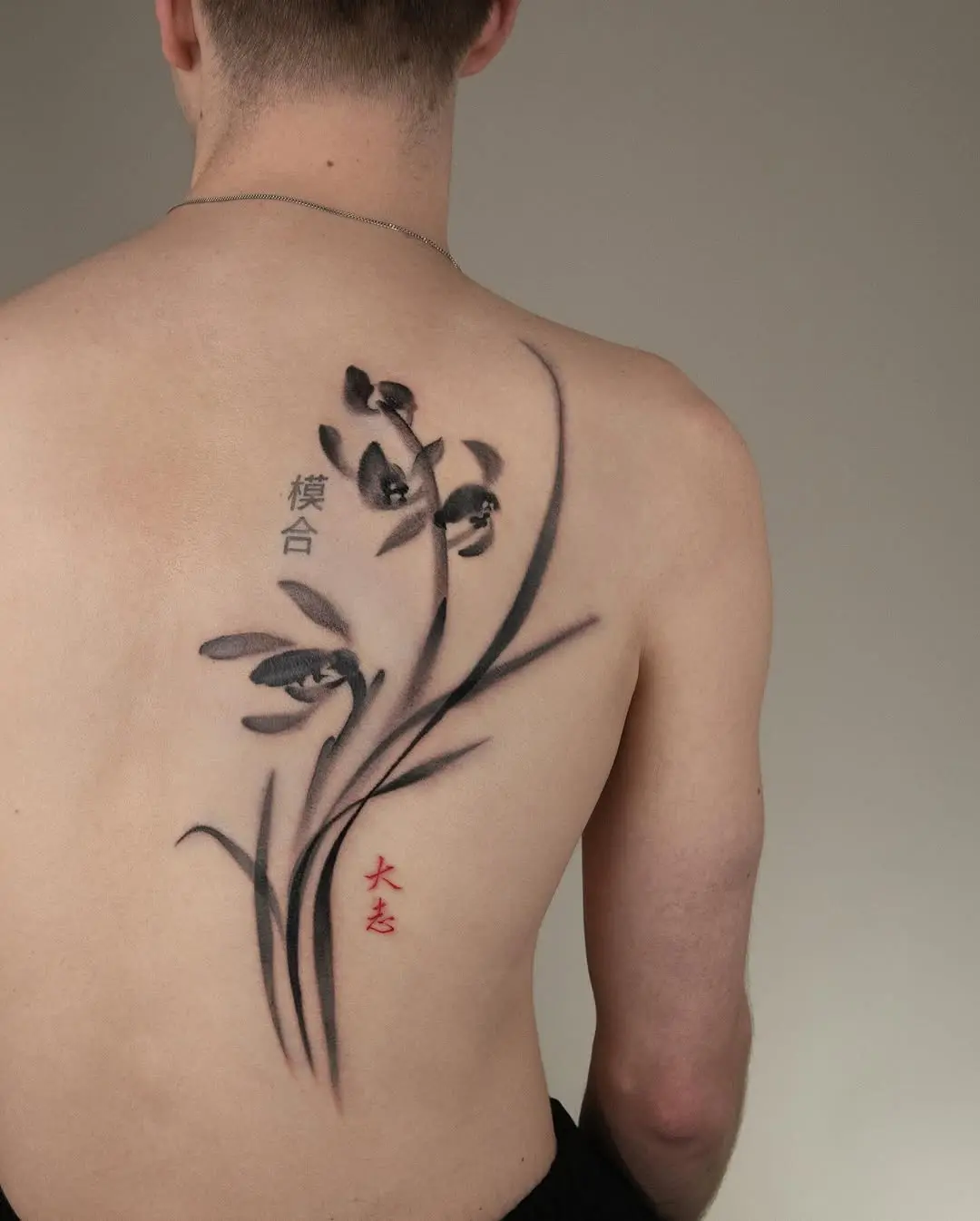 Elegant orchid tattoo with bold black ink.