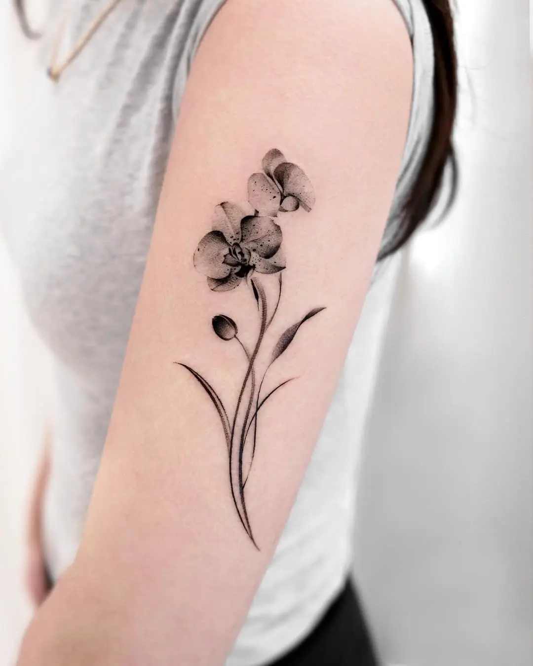 Elegant black and gray orchid tattoo on arm