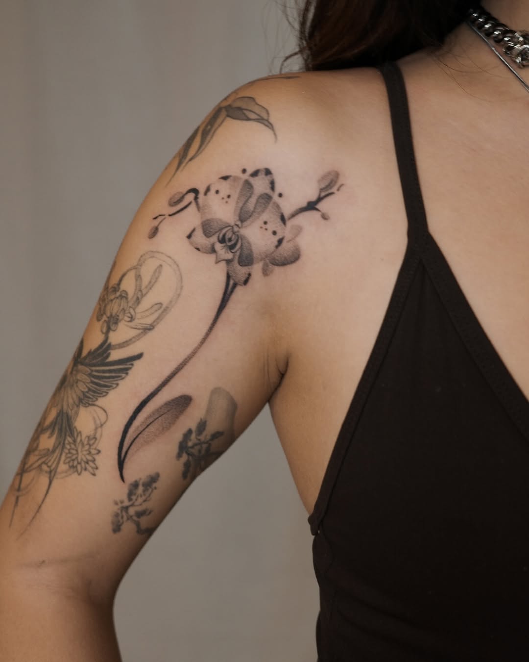 Elegant orchid tattoo on the shoulder