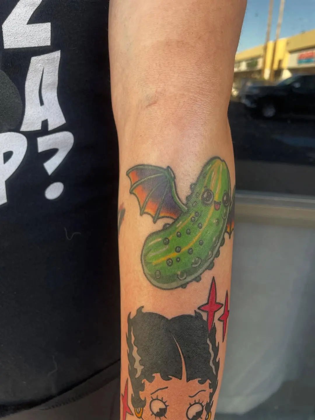 Quirky pickle tattoo with bat wings
