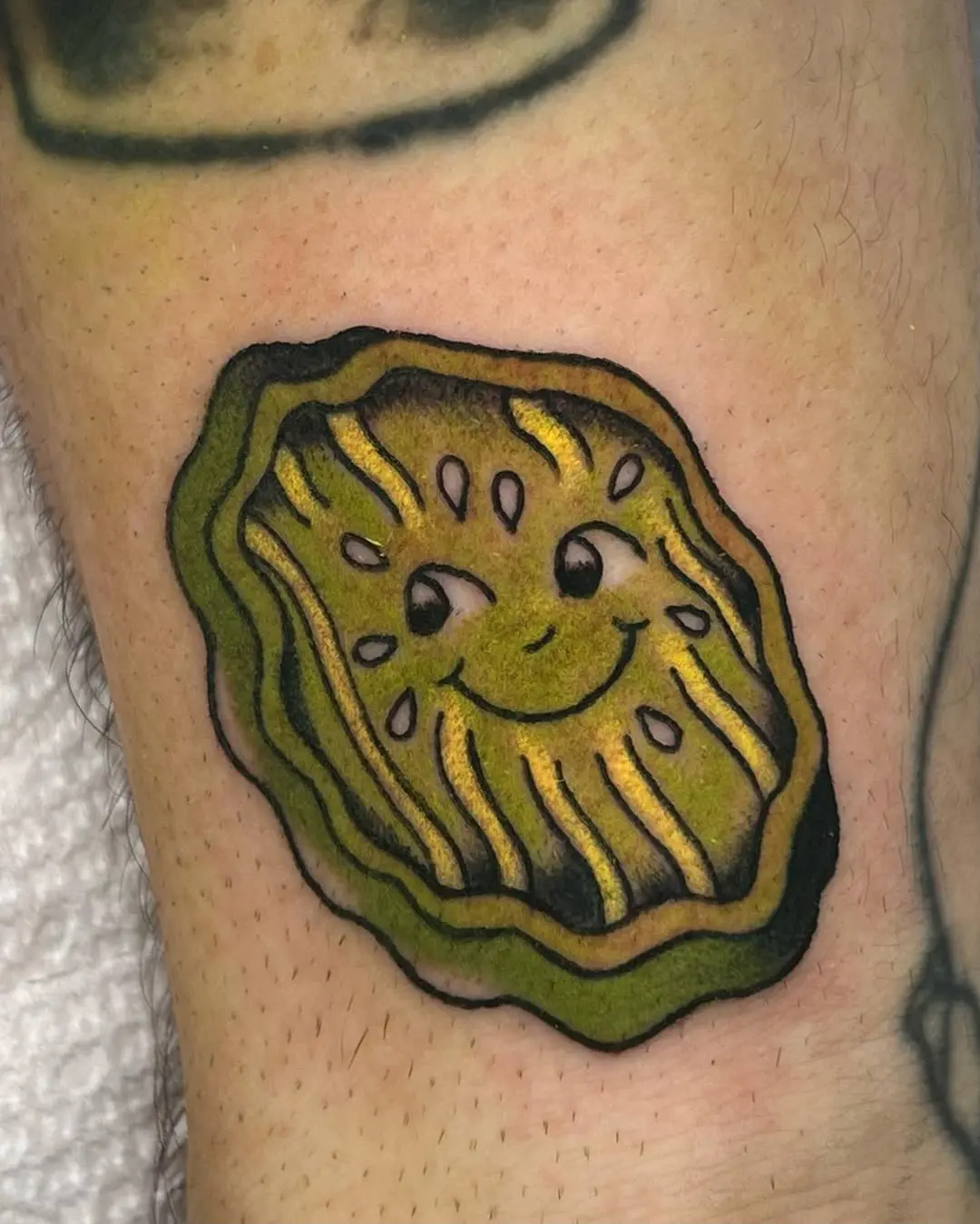 Playful pickle tattoo with a cheerful smile