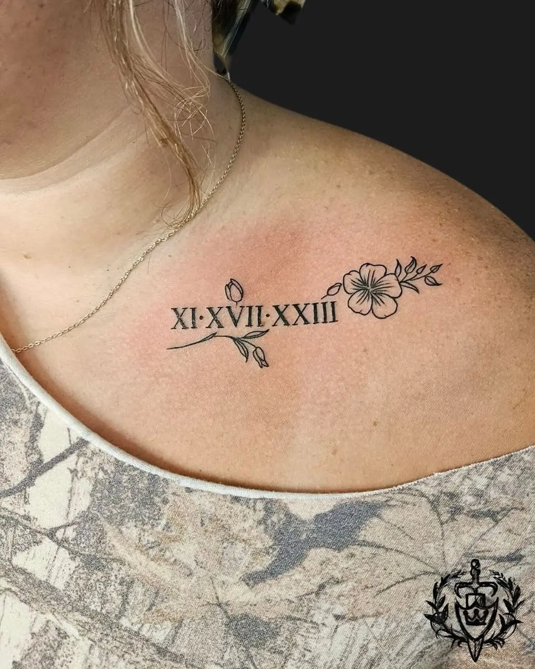 Elegant roman numeral tattoo with floral elements.